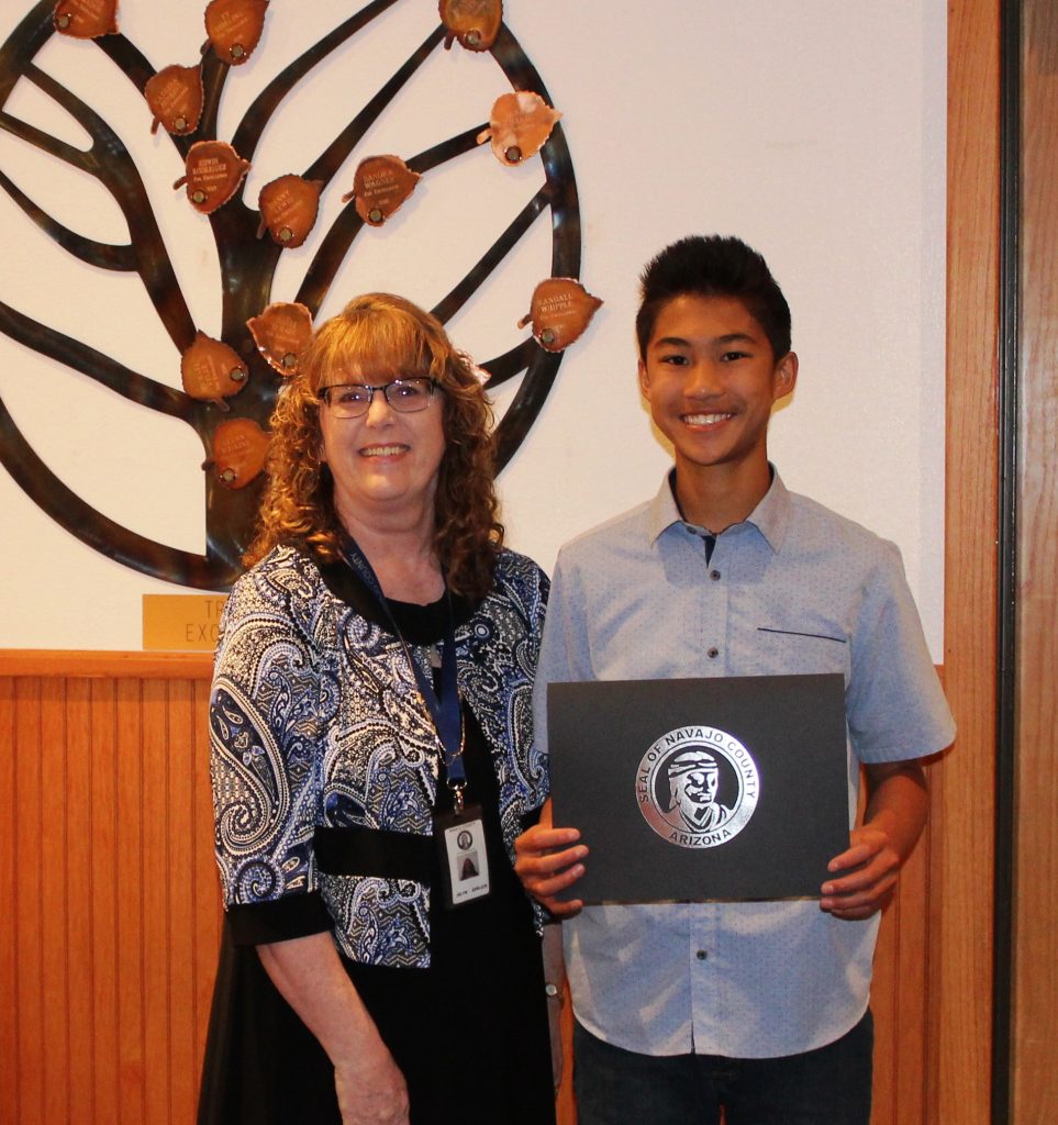 Photo by Toni GibbonsNavajo County Superintendent of School Jalyn Gerlich (left) presents Jett Jue (right), an eighth grade student from Winslow Unified School District and three time champion of the Navajo County Spelling Bee, with a certificate of achievement at the Navajo County Board of Supervisor meeting on May 8.