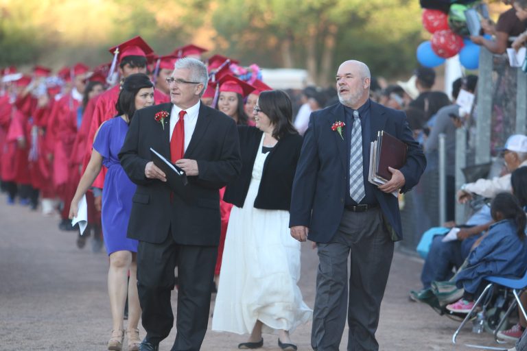 Holbrook High School Principal Lance Phaturos (left) and Assistant Principal Charles Haussman (right) lead the Class of 2018 out onto Roadrunner Stadium at the start of the graduation ceremonies.