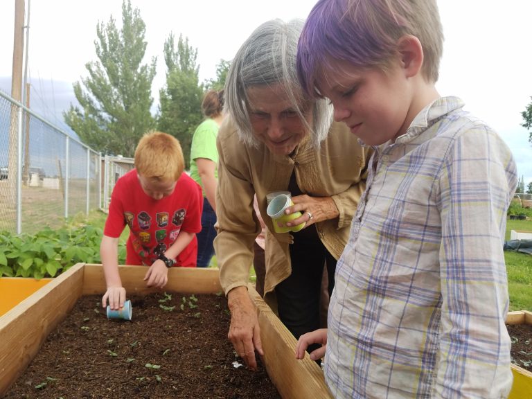 Photo by L. ParsonsPersephone Smith (right) learns about the benefits of earthworms in the garden from Sweetland Community Garden volunteer Linda Chambers (center).