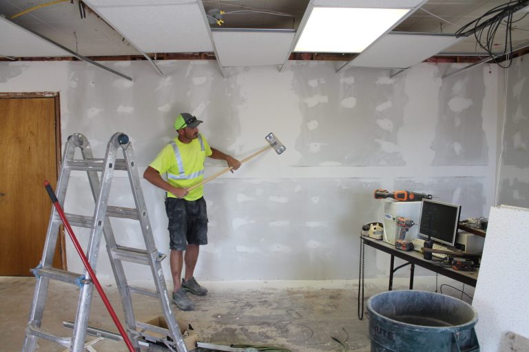 Photo by Linda KorThe Holbrook Municipal Airport pilot’s lounge is getting a renovation. Planning and Building employee Michael Young (pictured) smoothed out the seams on drywall as he finishes up the walls on the lounge. The renovation will be limited to the main room, which will have fresh paint, insulating windows and wood laminate flooring. The project to date has run approximately $2,900 in supplies.