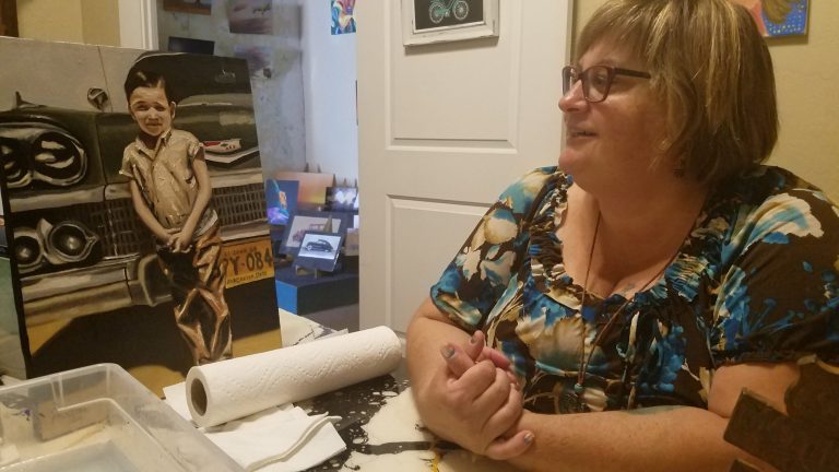 Photo by L. ParsonsGemini Gallery owner Linda Card admires a piece by local artist John Vasquez that will be featured in the Mother Road Art Show on Friday, Aug. 10.