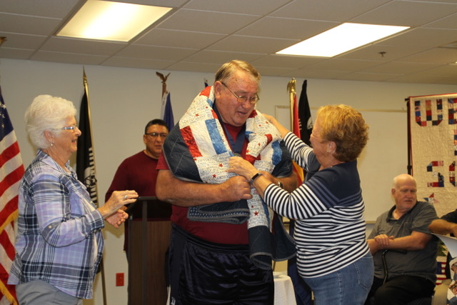 Photo by David C. SchneiderCarol Schilling (left) and Diana Vance (right) wrap Terrell Palmer, a Taylor resident who served in the Army from 1969-1970, in his Quilt of Valor at the awards ceremony hosted by Heart 2 Heart Quilts and Snowflake’s American Legion Post 126.