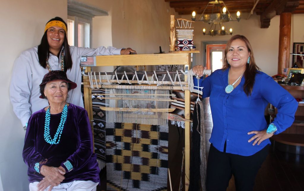 Photo by Toni GibbonsJacob (left) and Shannon Smith (right) stand beside their grandmother Lucille Smith (center), a Navajo master weaver who shares her story and artistry at the Painted Desert Inn at the Petrified Forest National Park as one of the cultural demonstrators.