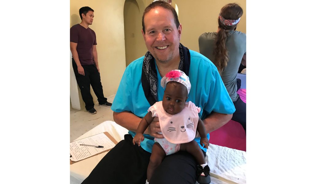 Photo courtesy of Lynn JohnsonSnowflake Mayer and Physical Therapist Lynn Johnson takes a break to share a smile with the little girl of one the Haitian interpreters that works at the Port-de-Paix, Haiti clinic run by Phoenix Rising for Haiti. Johnson spent a week in October helping take care of patients at the clinic. “These kids just melt your heart,” said Johnson.