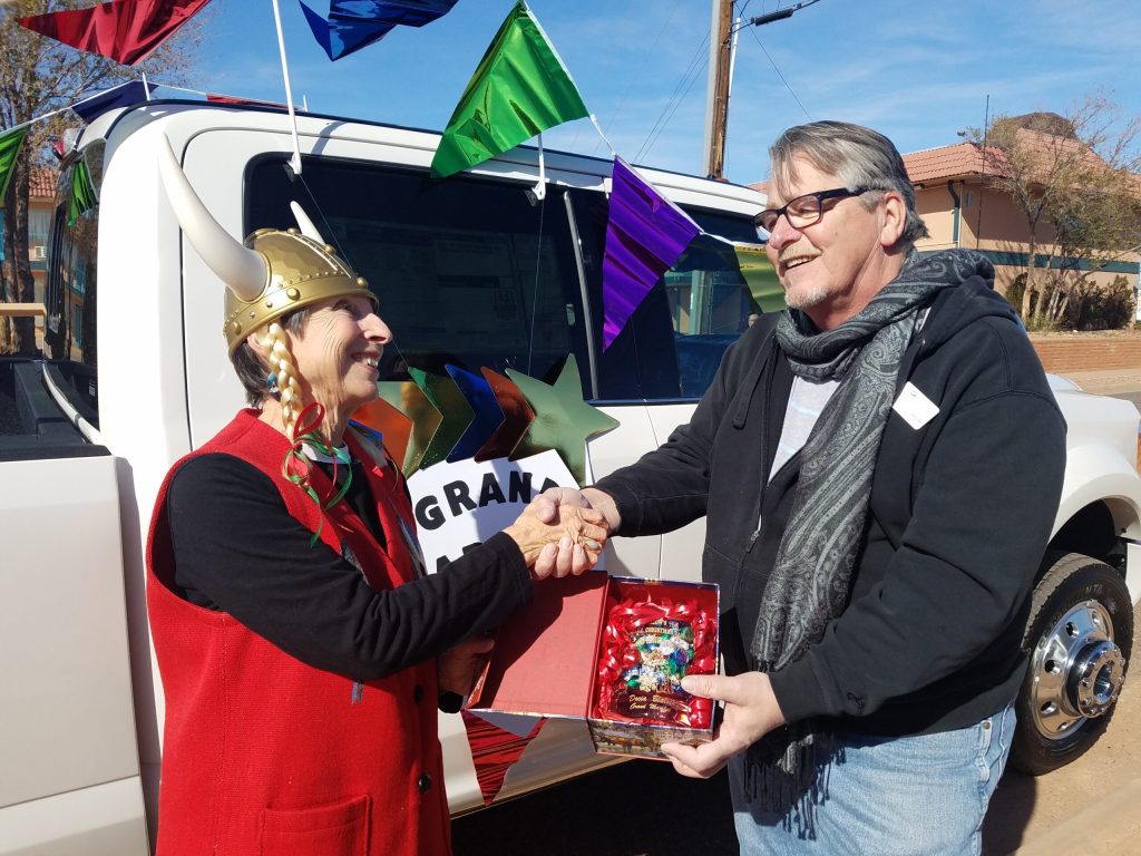 Photo by L. ParsonsRetired Winslow librarian Docia Blaylock (left) was given a gift by Chamber of Commerce CEO Bob Hall (right) as the grand marshal at last weekend’s Christmas Parade. Blaylock said, “I am honored, and I am excited for this opportunity. What a great time for everyone!”