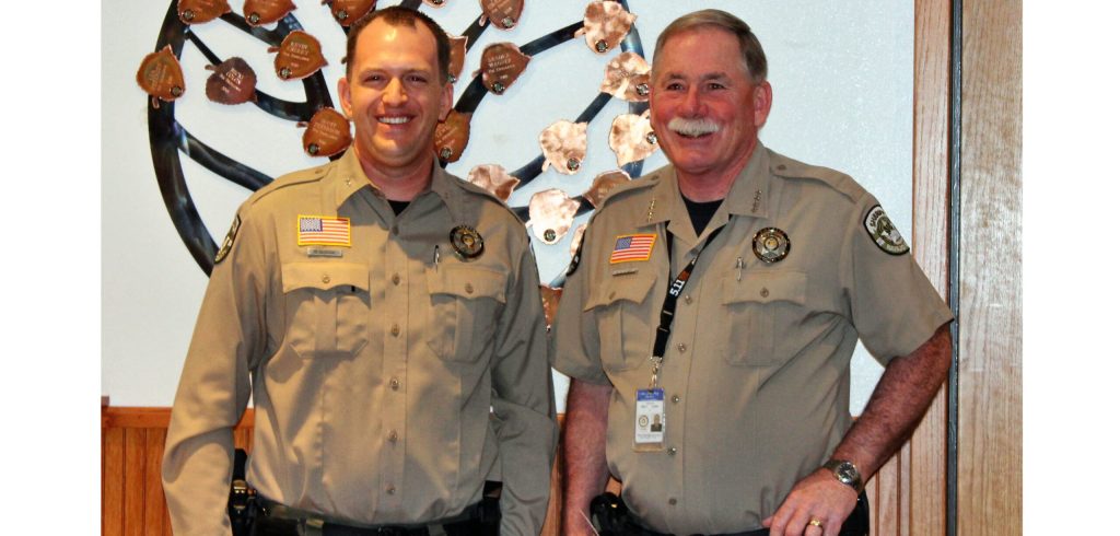 Photo by Toni GibbonsNavajo County Sheriff’s Office Sergeant David Clouse (left) stands with Sheriff KC Clark (right) as Clark announces his plans to retire in February at the Navajo County Board of Supervisors meeting.