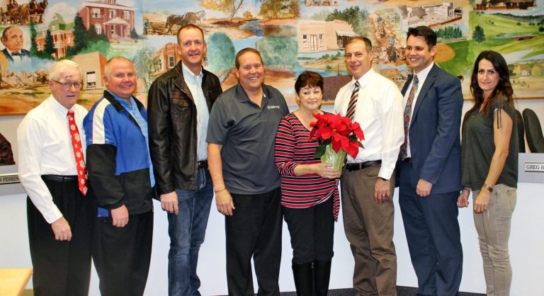 Photo by Toni GibbonsThe Snowflake Town Council recognized and thanked Barbara Bigler (center) with a gift of a poinsettia for all the time she has volunteered to repair and prepare the poinsettias displayed on the Main Street lamp posts each Christmas season for many years. Bigler is a longtime Snowflake resident and was an employee with the town where she served as the town clerk. Also pictured with Bigler are (left to right) Vice Mayor Kerry Ballard, councilmen Greg Brimhall, Cory Johnson, Byron Lewis, Hunter Lewis and Councilwoman Allison Perkins.