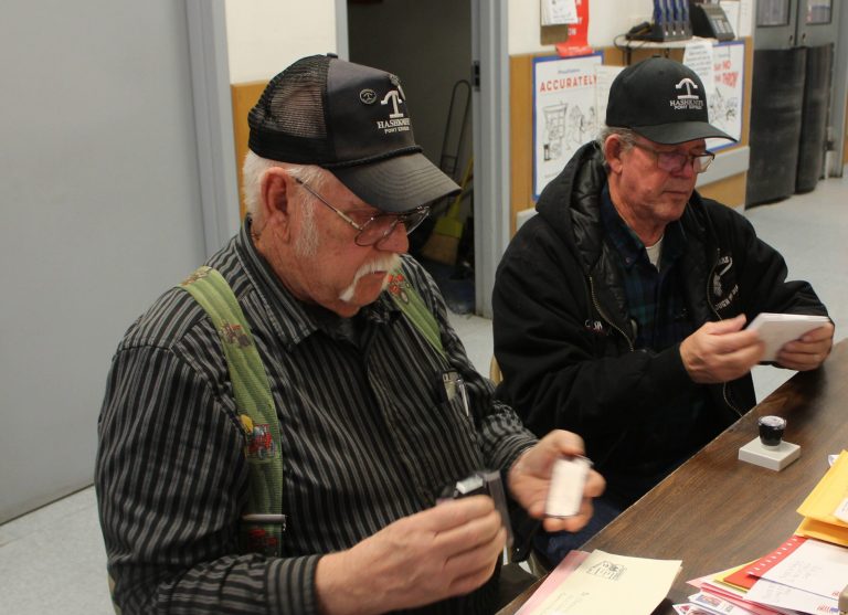 Photo by Toni GibbonsJim Mobley (left) along with Jerry Young (right) begin the ongoing task of hand cancelling and cacheting each letter before it is loaded into the mail bags in preparation for the 61st Hashknife Pony Express ride that began this morning (Feb. 6).