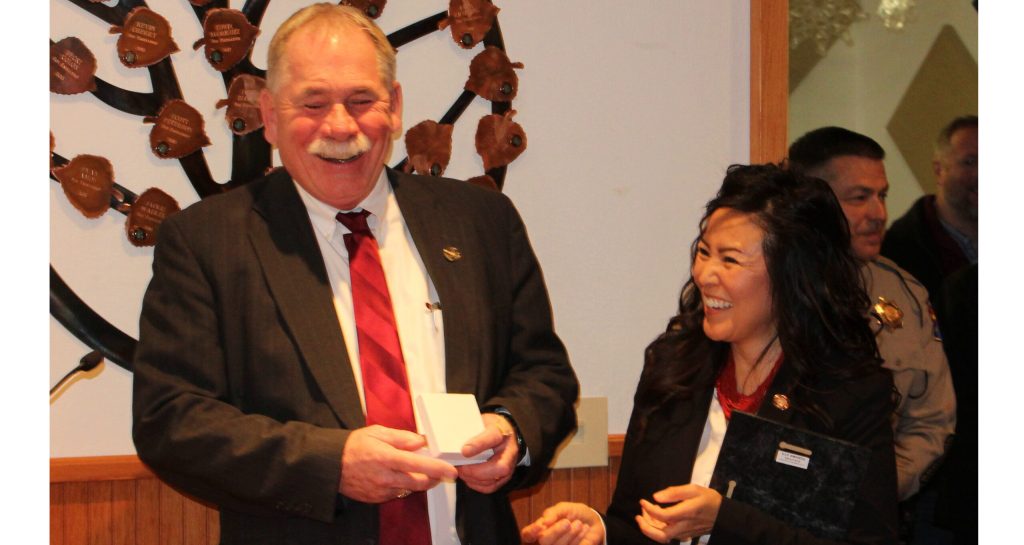 Photo by Toni GibbonsNavajo County Chairwoman Dawnafe Whitesinger (right) presents retiring Sheriff KC Clark (left) with a plaque of appreciation and a special ring made for him at the Feb. 12 meeting.