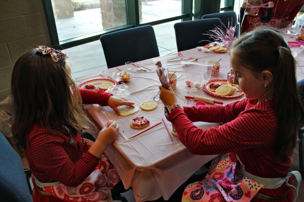 Photo by Toni GibbonsBrylee Montemurro (right), a third grader in Snowflake, works on decorating her cookies, while her sister, Kinsley Montemurro (left), a first grader in Snowflake, puts the finishing touches on her cookie at the Northland Pioneer College Valentine’s Day cookie decorating event on Feb. 9 at the Silver Creek Campus.
