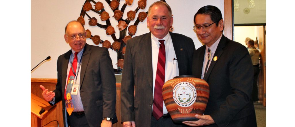 Photo by Toni GibbonsAs the Navajo County Board of Supervisor’s honored Sheriff KC Clark (center) as he retires from office, Clark and County Attorney Brad Carlyon (left) took a moment to honor their friendship with Navajo Nation President Jonathan Nez (right) giving him a specially made Navajo pot honoring Nez’s time as county supervisor from 2009 to 2015 and now the president of the Navajo Nation.
