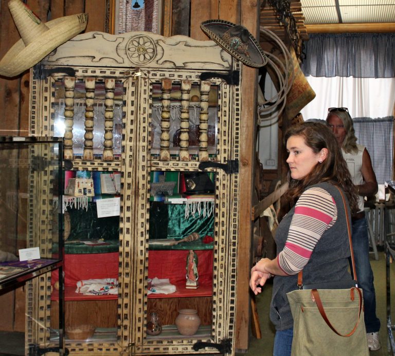 Photo by Toni GibbonsColleen Marsh, secretary for the Holbrook Chamber of Commerce Board, stands in front of curio cabinet at the Historic Courthouse Museum that was originally made for the Painted Desert Inn at the Petrified Forest. The courthouse holds many treasures that may now be in danger.