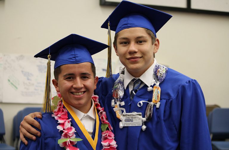 Seniors KJ Kinlicheenie (left) and Damon Sandoval (right) share a final moment together before heading to the stage to graduate.