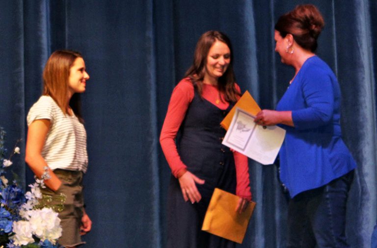 Photo by Toni GibbonsSnowflake-Taylor Chamber of Commerce Director Charlotte Hatch (right) gives two $500 scholarships to Hailey Wood (left) and Faith Rogers (center) at the Snowflake High School Senior Assembly on May 23. This is the second year the chamber has offered these scholarships from the money collected through the lunch bag program.