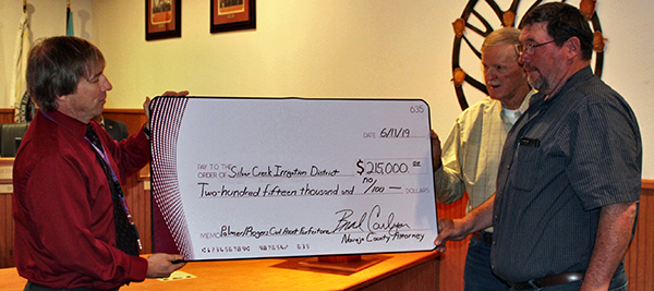 Photo by Toni GibbonsNavajo County Deputy County Attorney Jason Moore (left) presented a check for $215,000 to Silver Creek Irrigation District board members Dee Johnson (center) and Vance Muder (right) as a result of a successful civil assets forfeiture case.