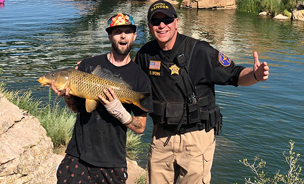 Photo courtesy of the Arizona RangersAngler Zach Robertson (left) lands the largest fish in the fishing derby during Clear Creek Days held last weekend in Winslow. Congratulating him is Major David E. Brown of the Arizona Rangers (right) who was one of the many members of law enforcement who ensured the event was safe and fun for all who took part in celebrating one of Winslow’s favorite amenities.