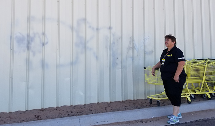 Photo by China CassidyDollar General Manager Irma Pogue shows the side of the building where an attempt was made to remove graffiti that was left there.
