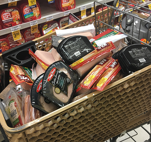 Photo by Linda KorThis cart filled with sealed deli meats at the Holbrook Safeway were two days past the “sell by” date and discarded in the trash. According to employees, this is a common occurrence and part of policy.