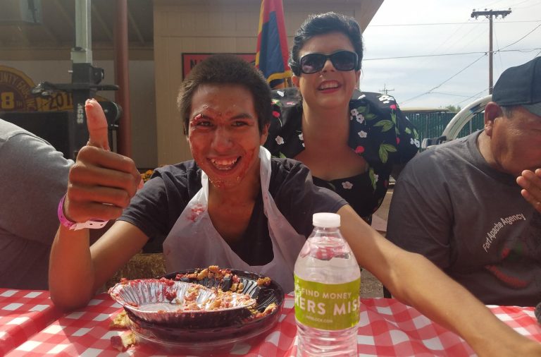 Photos by L. ParsonsJustin Camfield (pictured, seated) of Holbrook ate his way to first place and a $75 prize in the pie eating contest at the Navajo County Fair while Jillian Stotts of The Cherry Bombs looked on. Camfield beat 19 other contestants.