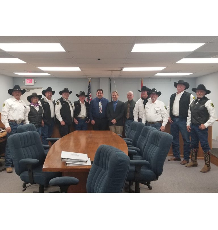 Photo by China Cassidy The Hashknife Sheriff’s Posse Pony Express members including (left to right) Chairmen of the Board Tim Kelley, John Veendendaal, Aaron Colon, Jim Mobley, Greg Long, and Mayor Merrill Young, City Manager Ted Soltis, Councilman Tim Dixon, and other members Robert Black, Jerry Young, Scott Self and Walter Pocheco gathered for a photo after Mayor Young declared Feb. 3-8 as “Hashknife Pony Express Week”