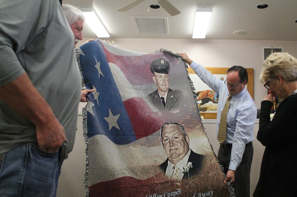 Sherry Cosper (right), the wife of late Vice Mayor Carl Cosper, was presented with a memorial blanket bearing Cosper’s image from the Taylor Town Council. Newly appointed Vice Mayor Jason Brubaker (left) holds up one side. Cosper passed away on Nov. 6.