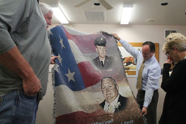 Sherry Cosper (right), the wife of late Vice Mayor Carl Cosper, was presented with a memorial blanket bearing Cosper’s image from the Taylor Town Council. Newly appointed Vice Mayor Jason Brubaker (left) holds up one side. Cosper passed away on Nov. 6.
