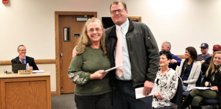 Photo by Amanda NicholsDoris Davis (left) was recognized by the district governing board for her 41 years of service as a teacher at Taylor Elementary School. Principal Jeremy Hatch (right) spoke fondly of her as he read from a letter he had prepared for her.