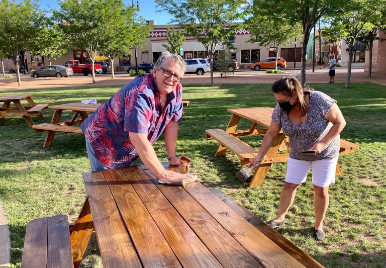 Photo by Roberta Wilcox CanoMembers of the community joined Chamber of Commerce CEO Bob Hall (left) and Angela Moser (right) in staining picnic tables to be used in the Route 66 Plaza on Second Street. According to Hall, this effort is to help promote physical distancing while enjoying a meal in the city’s historic district. The tables were provided by the chamber of commerce.
