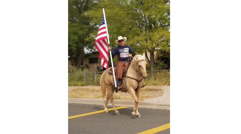 Photo by China CassidyIn honor and memory of the Americans who lost their lives and the lives of family as a result of the terrorist acts of 9/11, Holbrook resident Tim Kelley rides on horseback with the American flag traveling nine blocks south down Navajo Blvd. and 11 blocks west on Hopi Drive.