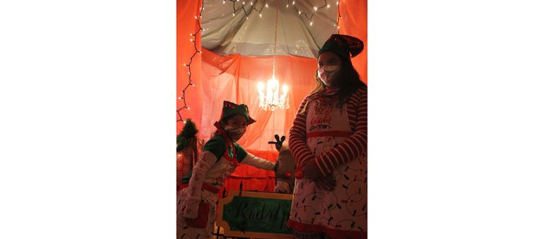 Photos by China CassidyEllie Tetrick, 6, (left) and Riley Gishie, 11, (right) kept Rudolph company while he waits for the kids to come and say hello at the Classic Christmas Story walk-thru display at the Navajo County Fairgrounds last Saturday.
