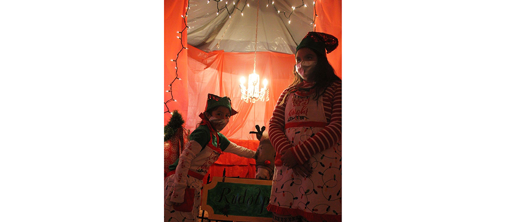 Photos by China CassidyEllie Tetrick, 6, (left) and Riley Gishie, 11, (right) kept Rudolph company while he waits for the kids to come and say hello at the Classic Christmas Story walk-thru display at the Navajo County Fairgrounds last Saturday.