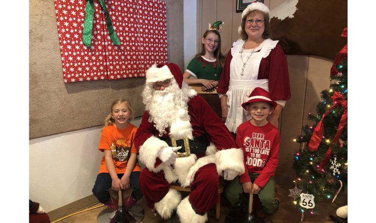 Photo by Linda KorSanta Claus made a stop at Esther’s Diner in Joseph City over the weekend, visiting with kids and adding them to his gift giving list. Visiting with Santa and Mrs. Claus (second from the right) is Alexis Carroll (left). Santa’s helpers included Danika Pounds (center) and Mikey Pounds (right). Bringing this joyful event to the kids was Kim and Diana Shelley.