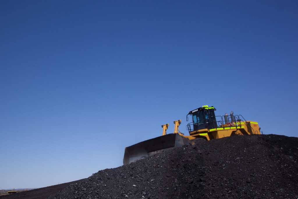 Photo courtesy Peabody EnergyA bulldozer crawls over a pile of coal at the Kayenta Mine on the Navajo Nation in this photo from 2012. The mine closed in 2019, but a program that distributes free coal to tribal members, one ton at a time, continues this year with coal from another mine on the reservation.