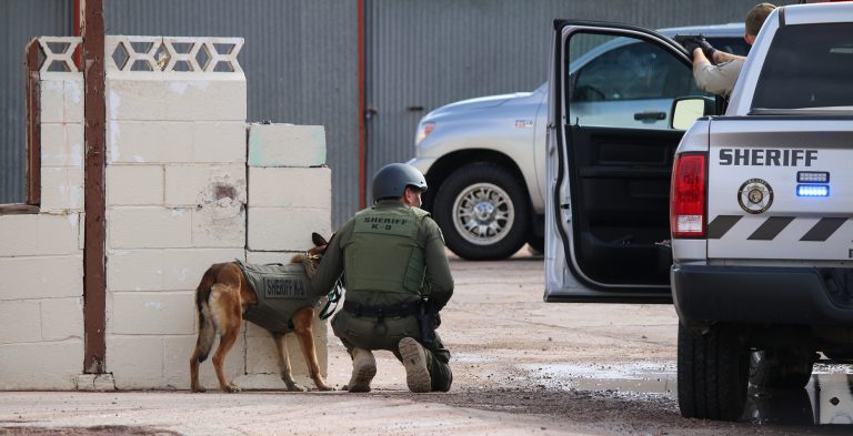 Photo courtesy of Navajo CountyA Navajo County deputy and K-9 Zolton are stationed outside the residence from where suspect Landon Martin eventually emerges.