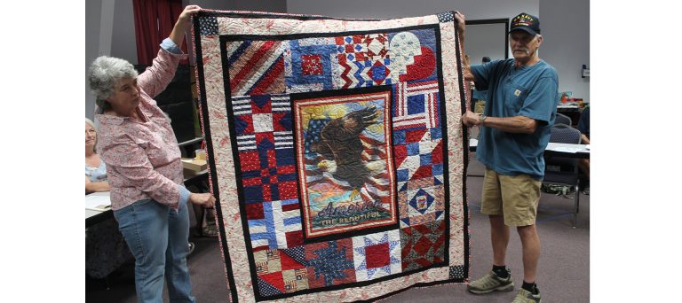 Photo by Linda KorVietnam veteran Bruce Askey (right) was presented with a veteran’s quilt created by the Dusty Desert Quilt Guild last week at the Holbrook Public Library. The guild members create a number of quilts each year to pay honor to veterans in the community who made great sacrifices by serving their country and preserving freedom. Assisting with presenting the quilt is Judy McCauley (left).