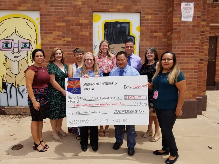 Photo by L. ParsonsThe Arizona Department of Corrections, Rehabilitation and Reentry Winslow Complex donated over $8,072.79 to the Winslow Unified School District last week. The money, raised through inmate and employee fundraisers throughout the year, will be shared amongst the five Winslow school sites. DOC staff, school administrators and principals were on hand to receive the check including (front row, left to right) DOC Administrative Secretary Liz Christiansen, Warden Ramiel Aguilar and DOC Executive Staff Assistant Shelayna Begay, (back row) Amber Martinez of Jefferson Elementary School, Amanda Leonard of Washington Elementary School, Deb Lopez of Winslow Junior High, Larissa Richards of Bonnie Brennan School, Sal Hernandez of Winslow High School and Superintendent Connie Gover.