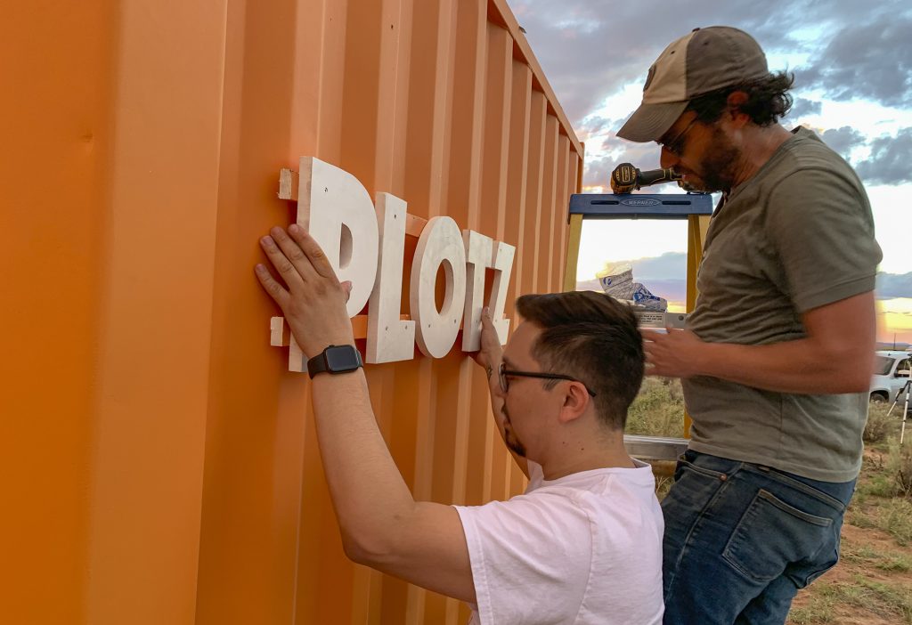 Photo courtesy of Joshua FoerLevi Tafoya (left) and Joshua Foer (right) installing the sign on the building for The Plotz Plot.