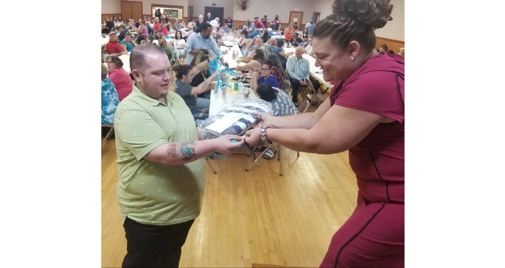 Photo by L. ParsonsThe annual Taste of Winslow was held last week as a fundraiser for the Winslow Chamber of Commerce. Many attended and participated in live and silent auctions as well as raffles. Here, Auctioneer Darcey McKee (right) hands raffle prize winner Daniel Von Spiegel (left) his prize. The fundraiser brought in a record breaking more than $12,000 for the Chamber to use for non-tourism related events in Winslow year-round.
