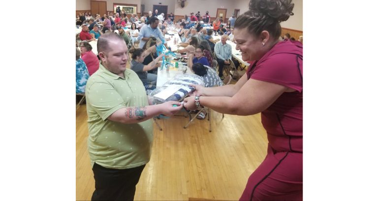 Photo by L. ParsonsThe annual Taste of Winslow was held last week as a fundraiser for the Winslow Chamber of Commerce. Many attended and participated in live and silent auctions as well as raffles. Here, Auctioneer Darcey McKee (right) hands raffle prize winner Daniel Von Spiegel (left) his prize. The fundraiser brought in a record breaking more than $12,000 for the Chamber to use for non-tourism related events in Winslow year-round.