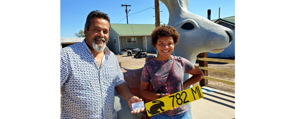 Photo by Cindy JaquezWhile on a trip along Route 66 with her family, a California girl (right) was undecided on whether or not to purchase a pair of earrings at a stop at Jackrabbit Trading Post. Owner Tony Jaquez (left) made a deal with her that if she could find five of the Jackrabbit mileage signs on their trip, that on the way back the earrings would be hers. There was one condition, she would have to find a sign in five different states and would have to buy one thing from each business and get a signature. She took the challenge and recently returned to collect her award and share her experiences.