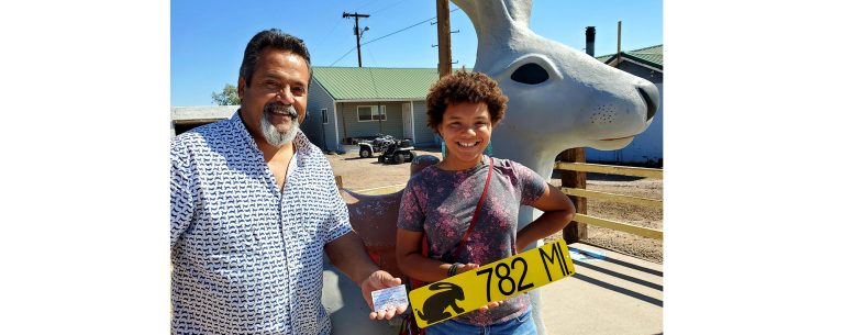 Photo by Cindy JaquezWhile on a trip along Route 66 with her family, a California girl (right) was undecided on whether or not to purchase a pair of earrings at a stop at Jackrabbit Trading Post. Owner Tony Jaquez (left) made a deal with her that if she could find five of the Jackrabbit mileage signs on their trip, that on the way back the earrings would be hers. There was one condition, she would have to find a sign in five different states and would have to buy one thing from each business and get a signature. She took the challenge and recently returned to collect her award and share her experiences.