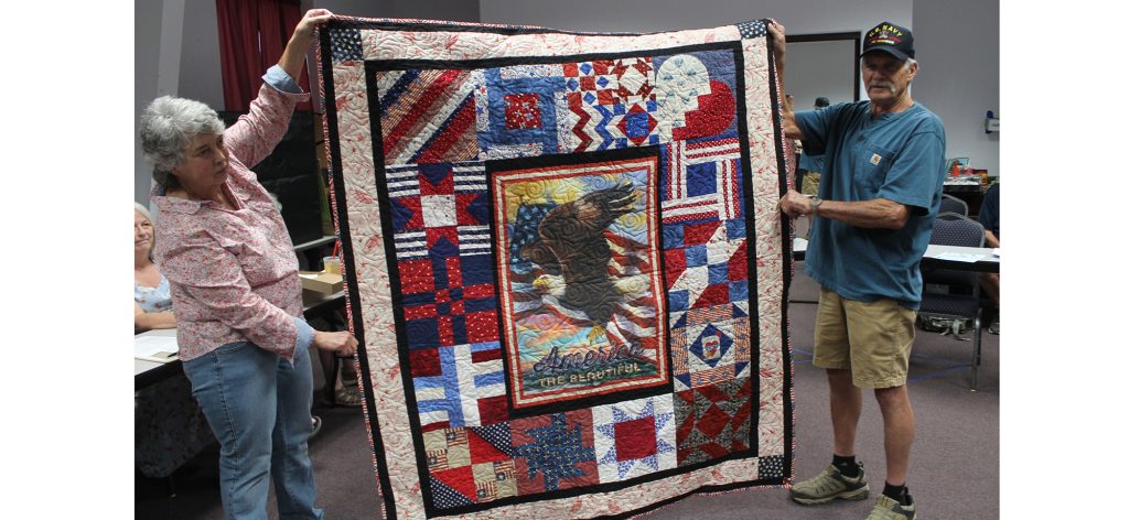Photo by Linda Kor Vietnam veteran Bruce Askey (right) was presented with a veteran’s quilt created by the Dusty Desert Quilt Guild last week at the Holbrook Public Library. The guild members create a number of quilts each year to pay honor to veterans in the community who made great sacrifices by serving their country and preserving freedom. Assisting with presenting the quilt is Judy McCauley (left).