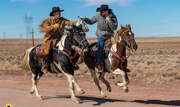 Photo by Nicole Reynolds/nicolereynoldsphotography.comClear Creek Cowboy Patrick Reynolds (left) makes the mail back handoff to fellow rider Nick Attenberger (right) along Territorial Road during the first Territorial Road Pony Express from Winslow to Holbrook held last Saturday.