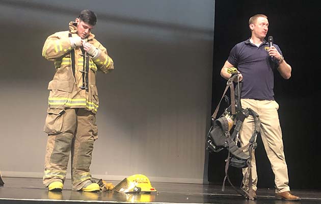 Photo by Linda KorNavy FCA1(SW) Brandon Ritter visited Holbrook High School on the invitation of Grow Arizona to talk to students regarding careers in the fields of fire science and internet technology. Senior Dillon Brewer stepped up and demonstrated speed and agility in suiting up in the fireman turnouts before jogging the entire auditorium in full gear.