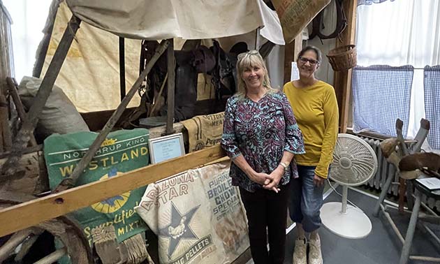 Photos by Linda KorNavajo County Historical Director Carol Windsor (left) and volunteer Sherry Reed (right) stand next to a covered wagon on display as one of the many exhibits at the Navajo County Historic Courthouse Museum.