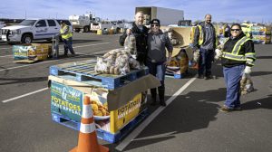 Photo by Richard LarsonResidents in Winslow got help for the holidays from Walther Farms, which gave away free bags of potatoes last week at the Hubbell building on Second Street. The drive-thru distribution was a big success with many grateful recipients taking part and plenty of volunteers on hand to help out.