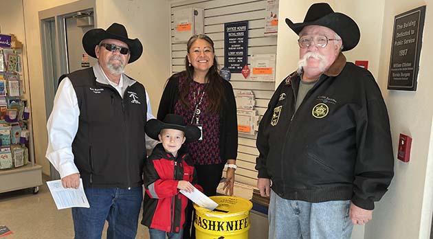 Photo by Linda Kor The Hashknife Posse is preparing for the 65th annual Pony Express Ride slated for Feb. 2 by setting barrels out to collect letters that will be delivered via horseback for the postal service. Here Hashknife Captain Mark Reynolds (left) helps his grandson Crawford Bielefeldt (front) drop in the first letter at the Holbrook Post Office while Postmaster Nancy Tom and Hashknife member Bill Perkins look on. Barrels have been placed at area post offices including in Winslow, Joseph City, Taylor, Snowflake, Heber, Overgaard, Show Low and Pinetop/Lakeside, as well as at Bienvenidos Restaurant in Holbrook. Be sure to submit a letter in a barrel prior to the Feb. 2 ride.