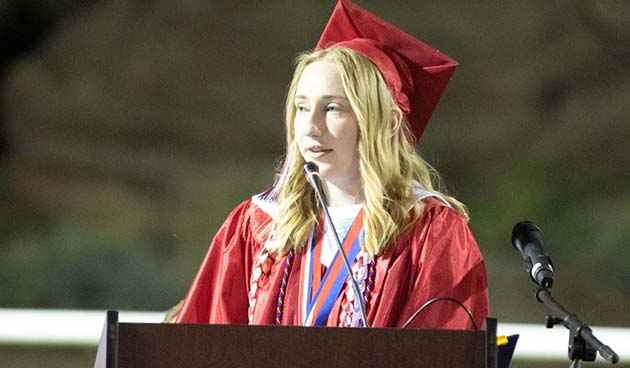 Photos by Kellie Spangler/SpanglerpicsValedictorian Kelly Hill addresses fellow graduates, friends and family at the graduation held at Roadrunner stadium.