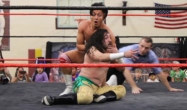 Photo by Shawn WhiteFlyboy Freddy (sitting) escapes the grasp of Joey Hendrix during their opening fight at Winslowmania 2.