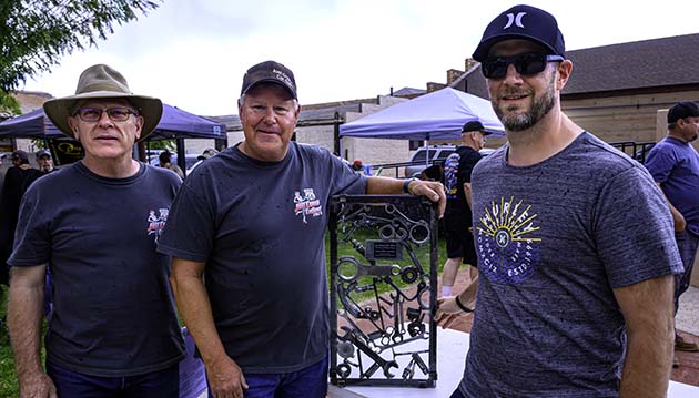 Photo by Richard LarsonThe Just Cruis’n Car Show was held in Winslow last week with Matt Hancock (right), a former Winslow resident, was the recipient of the Best of Show award for his red 1955 Ford F100 pickup truck. Also pictured are Harold Soehner (left) from the Leavitt Group who sponsored the Best of Show award and George Gould (center) who designed and welded the trophy.